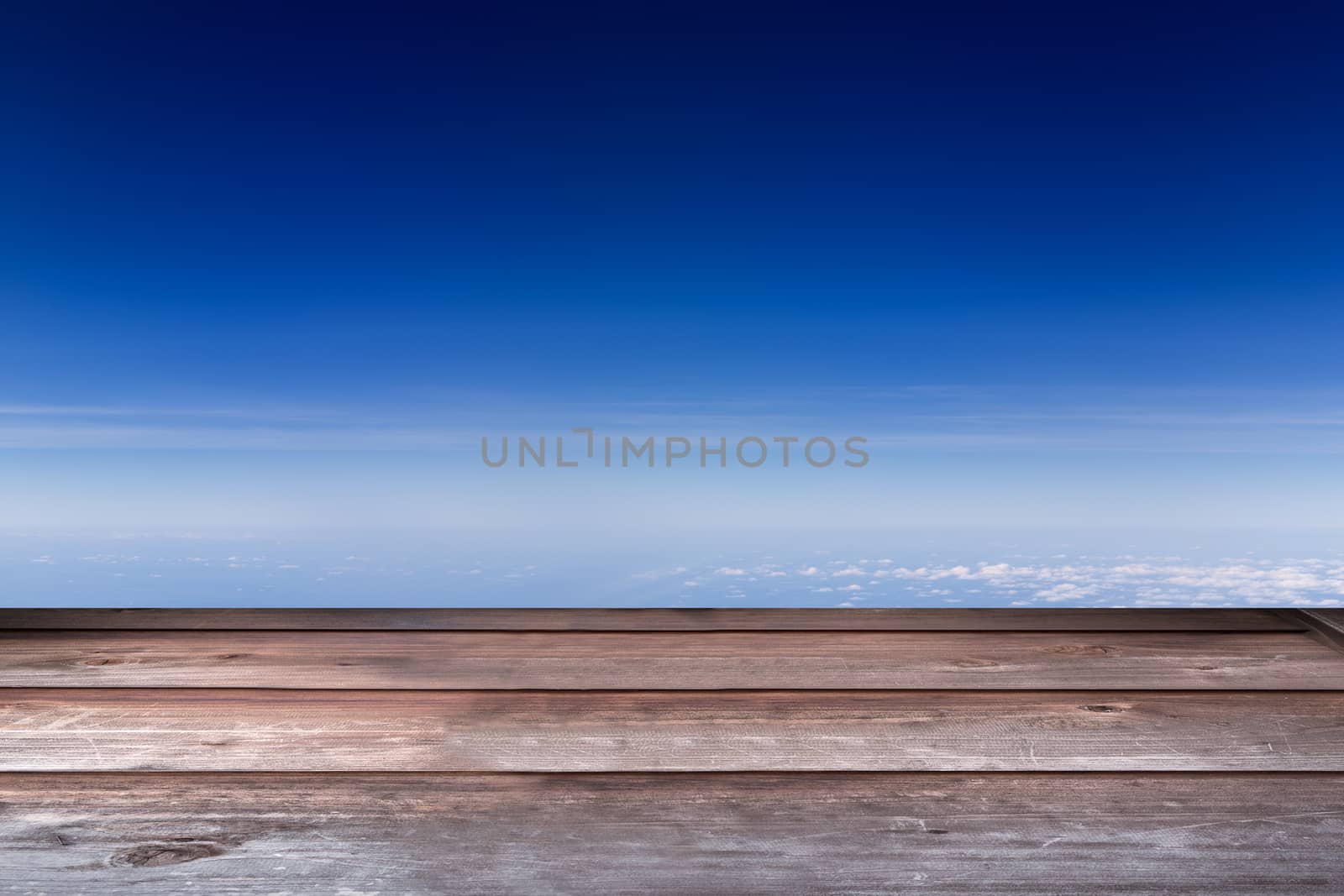 Wood tabletop in perspective view with blue sky background