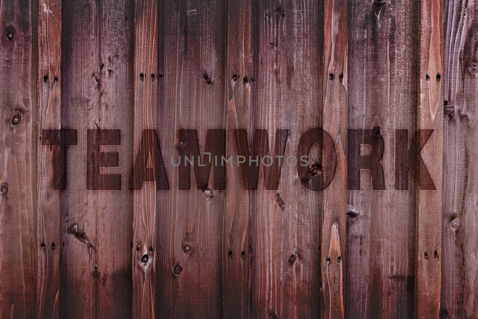 Teamwork word engraved on wood expressing teamwork concept.