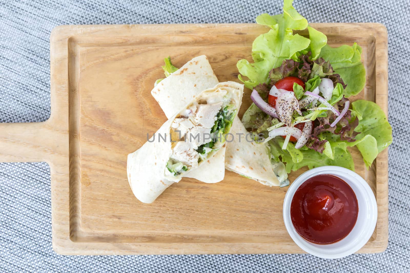 Chicken wrap with fresh vegetable on table.
