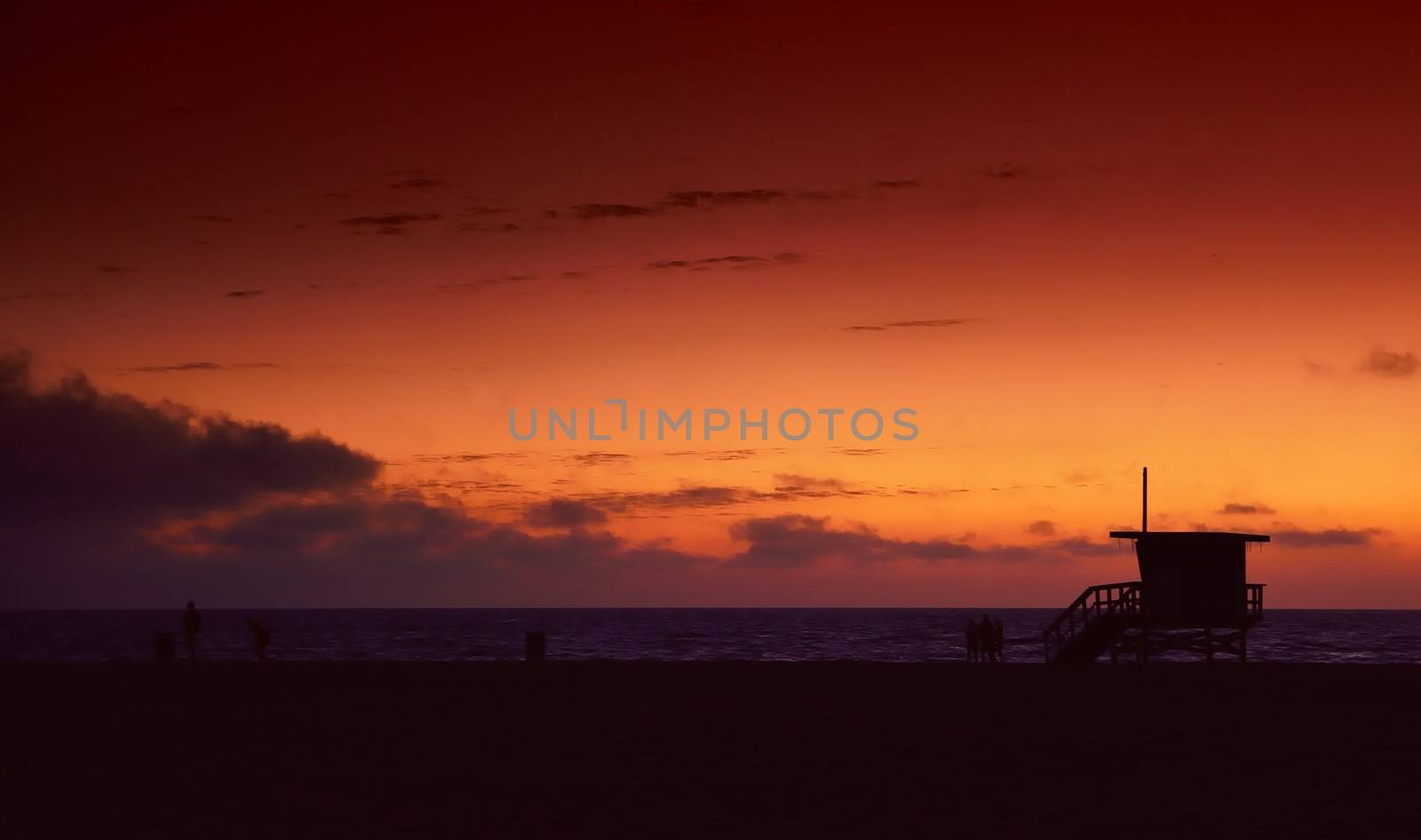 Lifeguard tower at sunset in Hermosa Beach, Los Angeles, California, in the background calm water