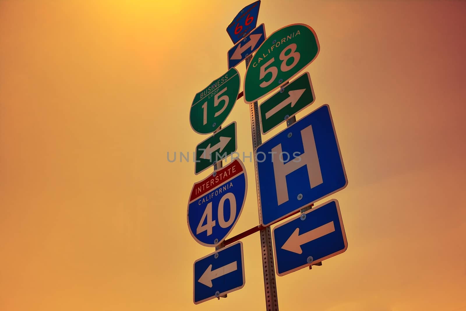 Interstate 40 road signs with dawn lights on San Bernardino county, California.
