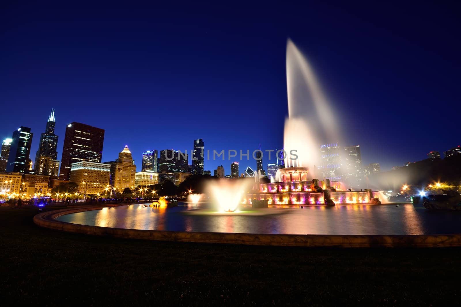 Chicago skyline panorama with skyscrapers and Buckingham fountain at night.