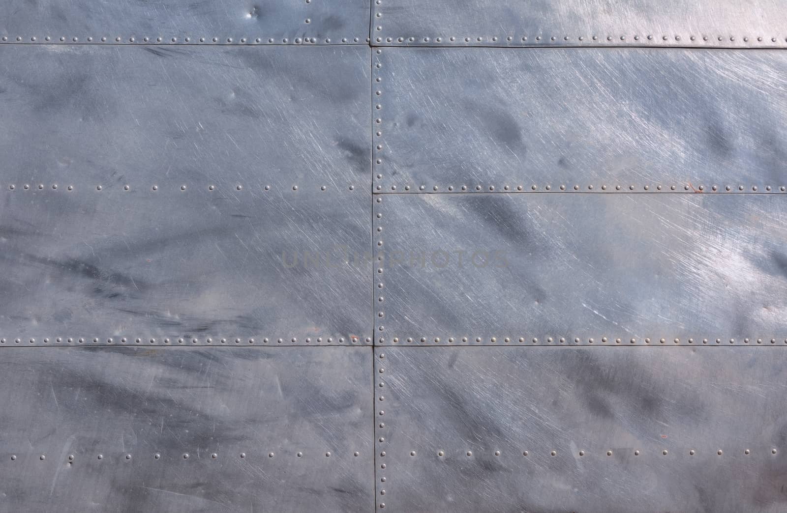 Airplane fuselage silver metal texture with rivets. Useful as background for design works.