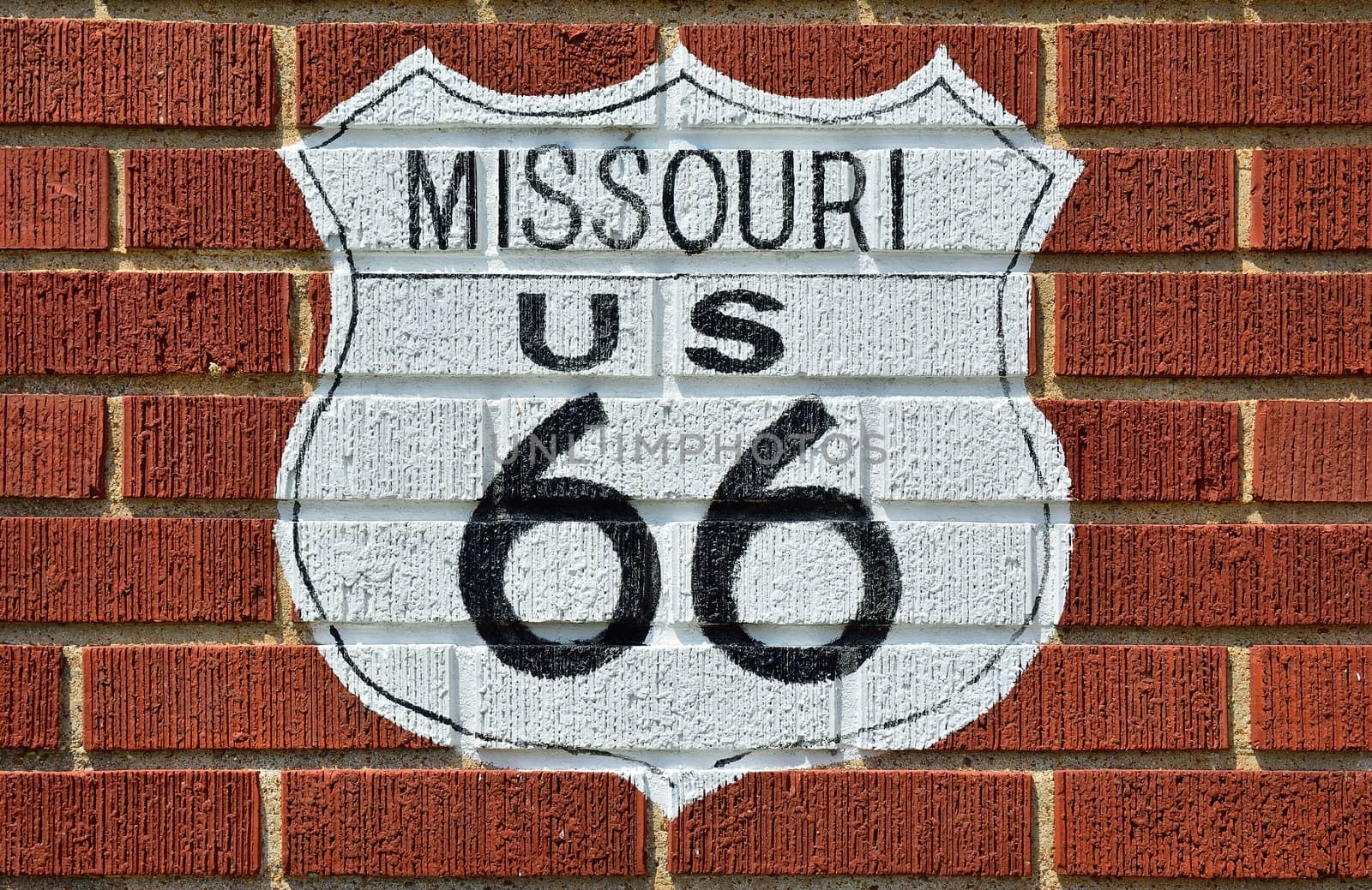 Historic Route 66 road sign painted on a brick wall in Missouri