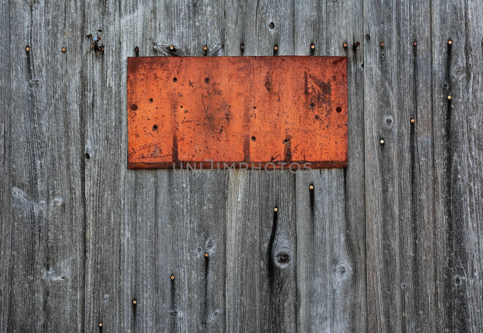 Rusty metal sign on wooden wall, copy space.