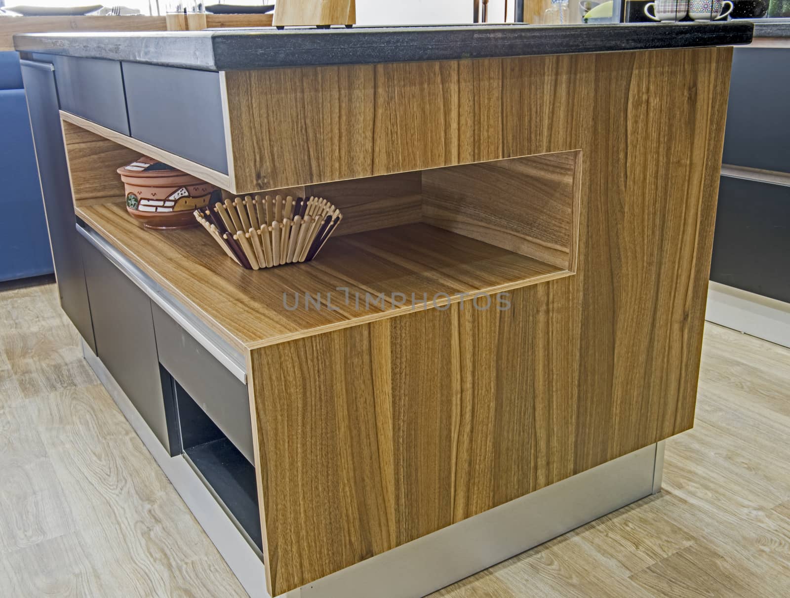 Interior design decor showing modern kitchen island with wooden shelf in luxury apartment showroom