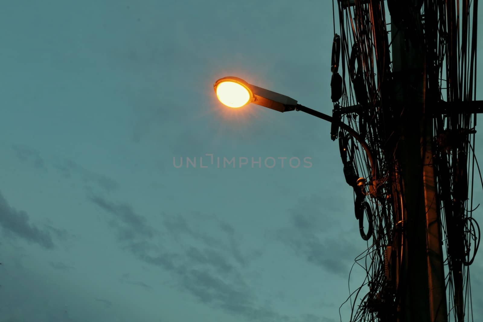 Street lights mounted on poles at evening time by cgdeaw
