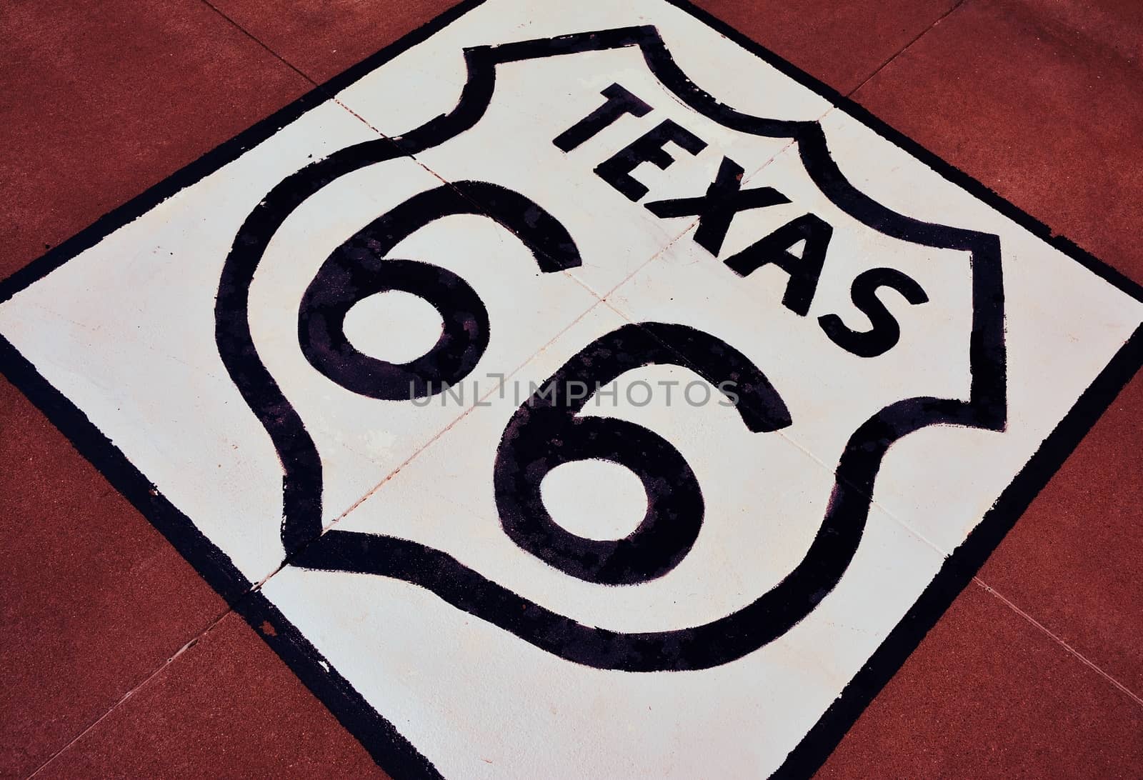Historic Route 66 sign on the asphalt in Texas.