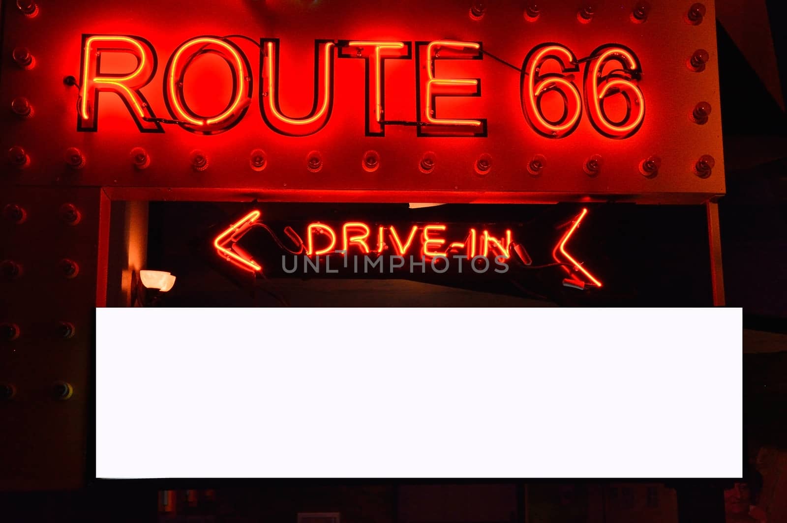 Historic Route 66. It is a neon sign in red against a black night sky. Copy space.