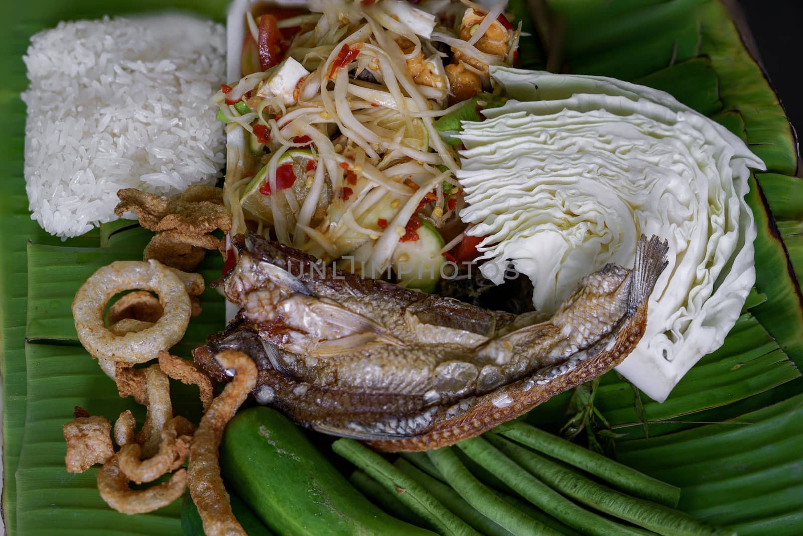 Isan Thai food Name papaya salad, pickled fish, salted egg With various machines Green banana leaf background