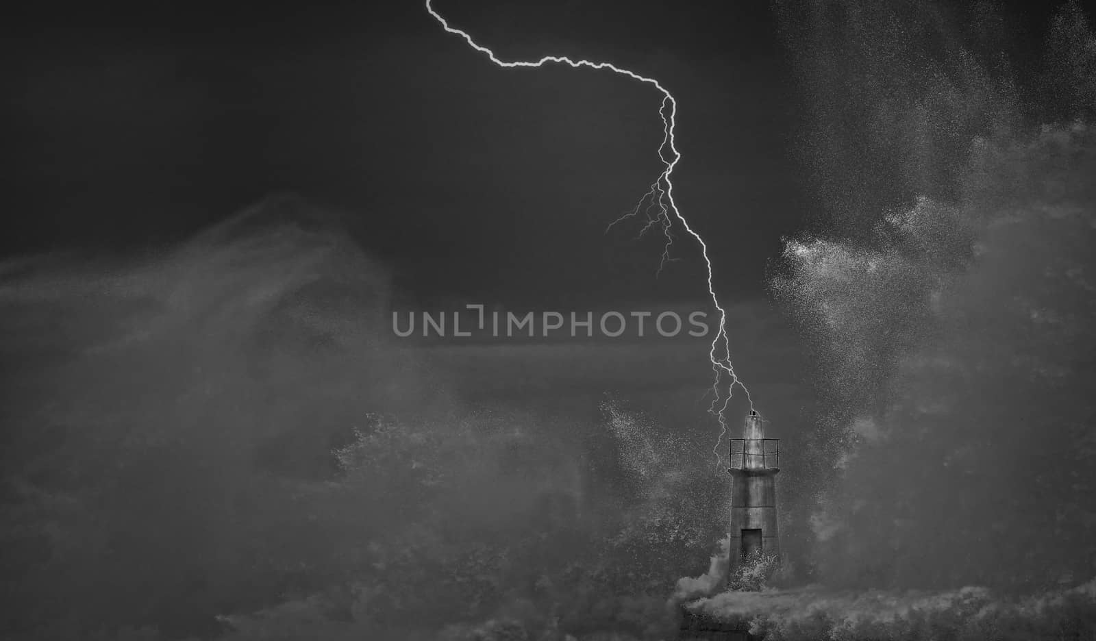 Lightning and wave over old lighthouse and pier of Viavelez in Asturias, Spain.