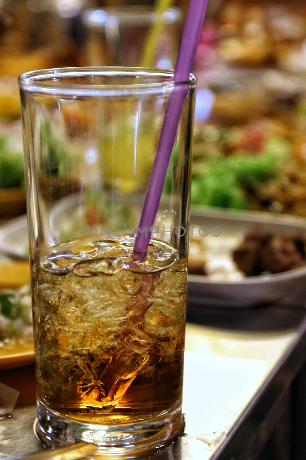 Drink cola water in a glass with ice on a table in a restaurant at night