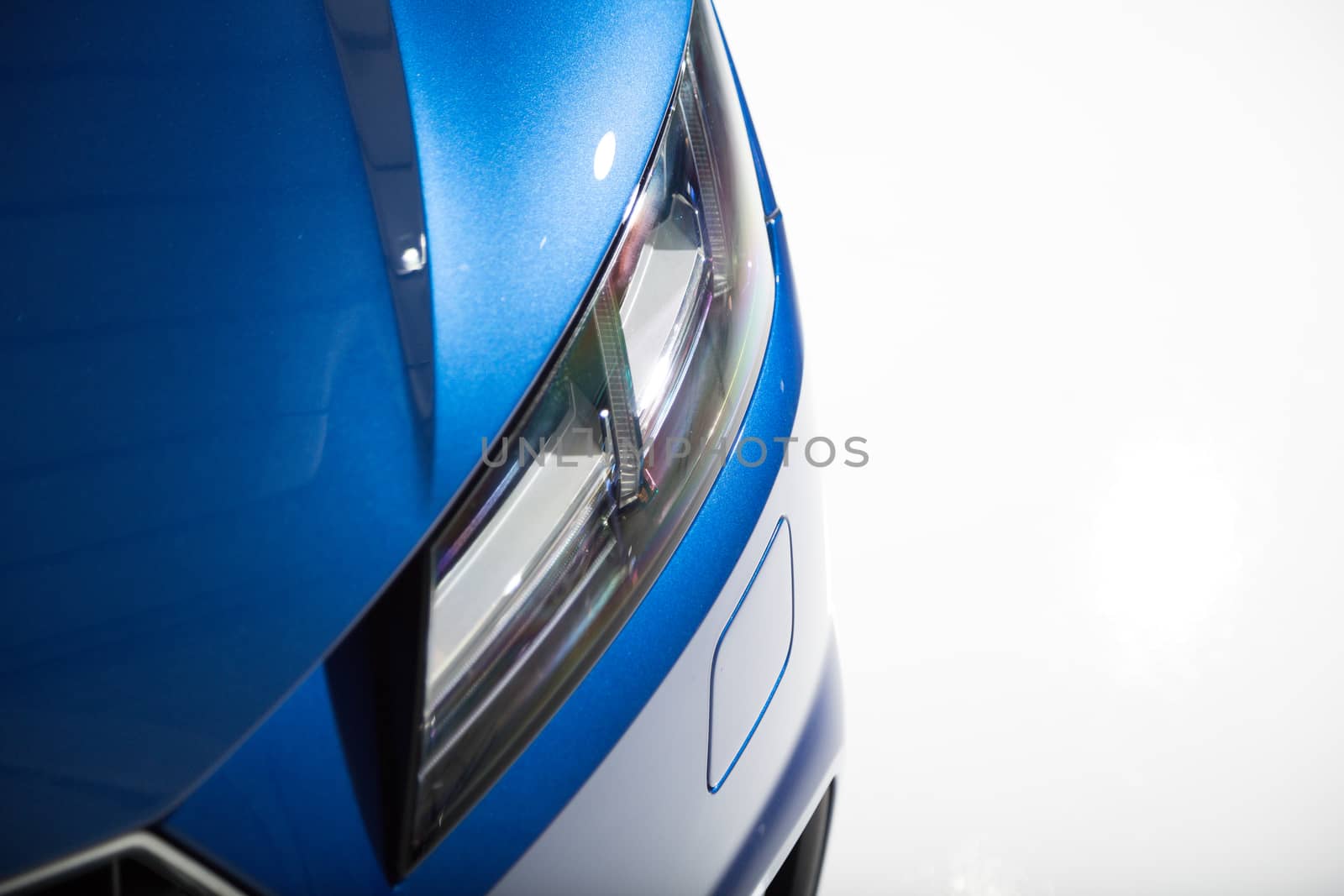 Close up of headlight on blue sports car