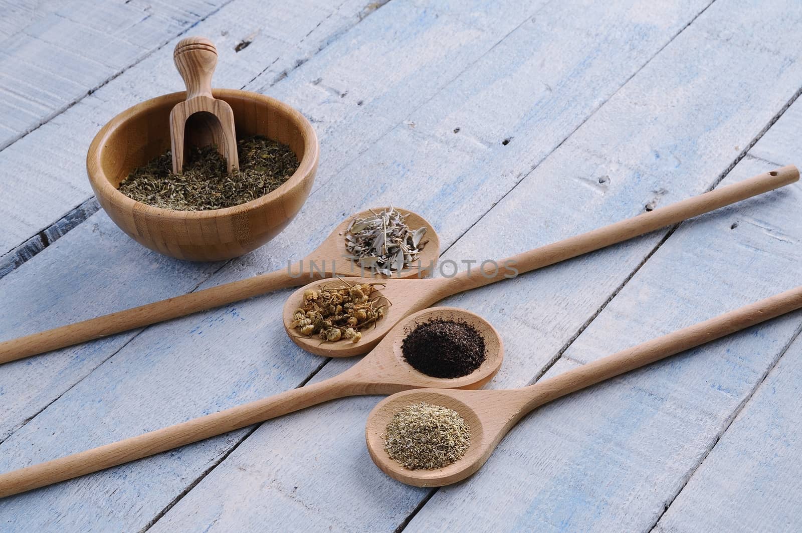Different spices in wooden spoons and in bowl