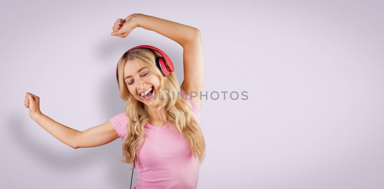 Beautiful woman dancing with headphones against purple vignette