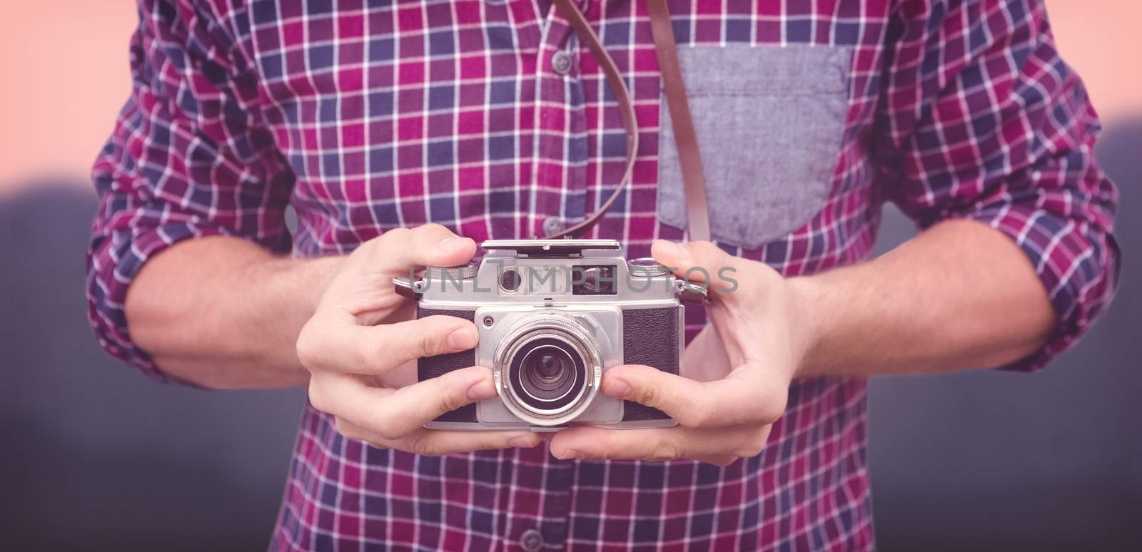 Mid section of man using camera against blurred mountains