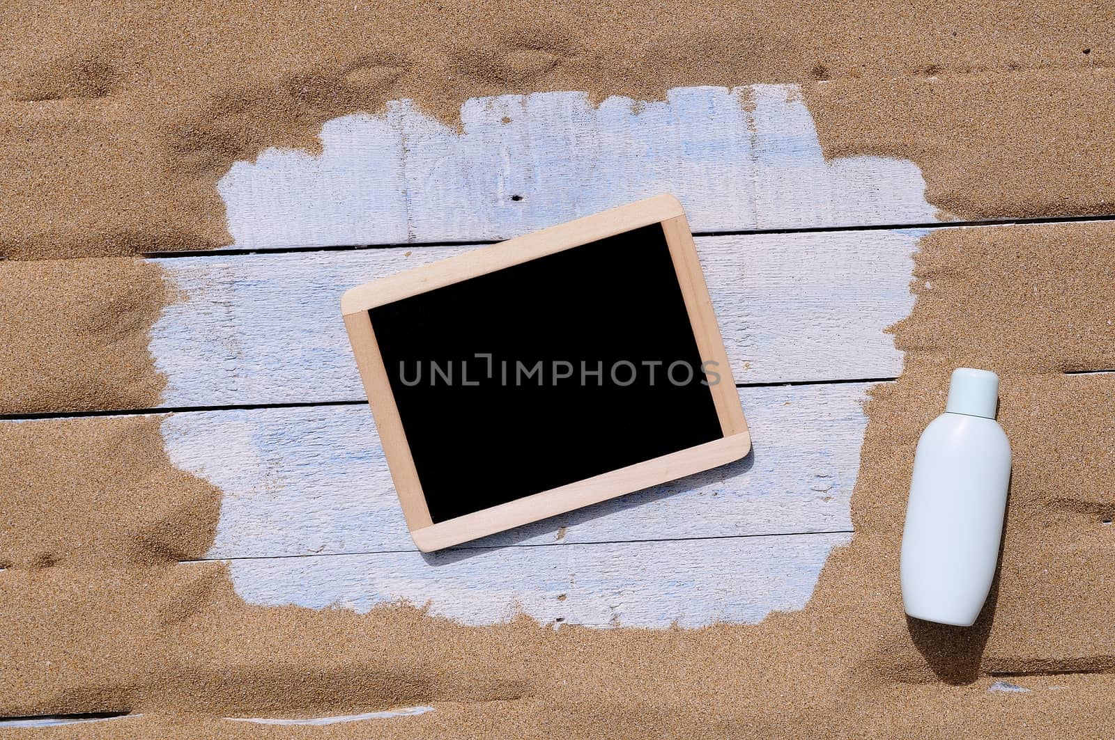 Black board in frame on blue wooden background. From above