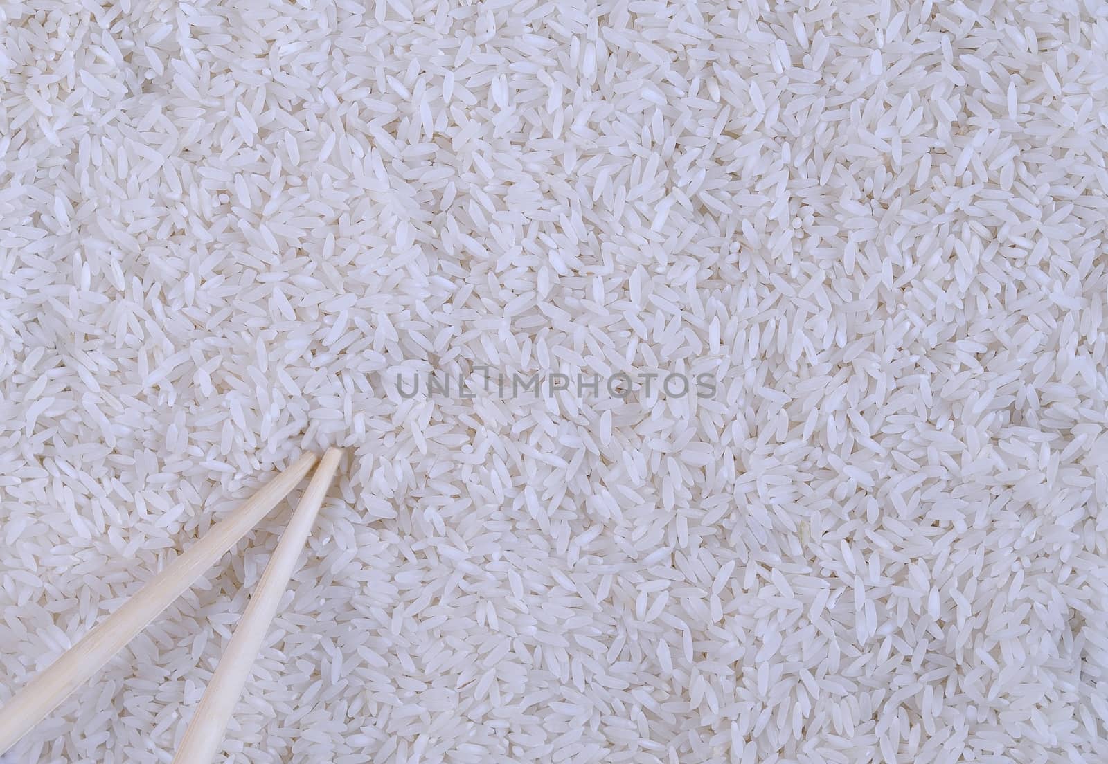 Close-up of white rice and wooden sticks. From above