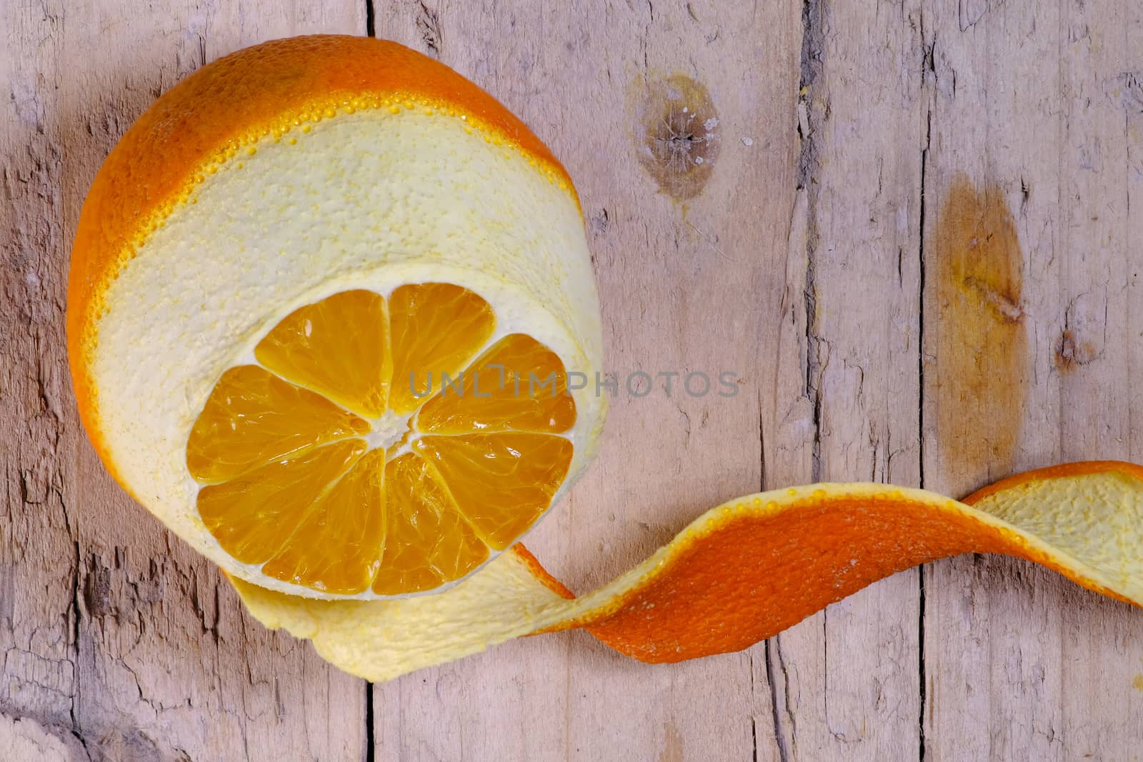 Ripe orange peeled on old wooden background