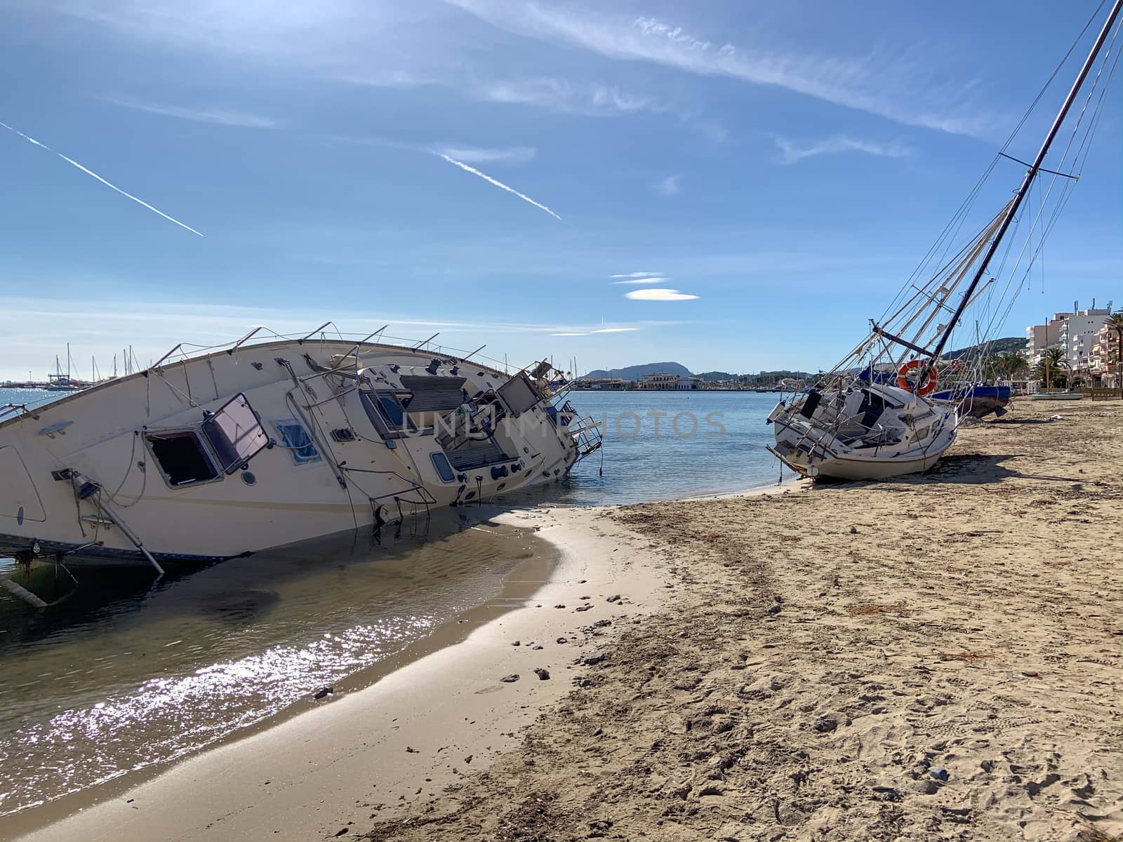 Several boats stranded on the beach after a storm. On a sunny day with few clouds.