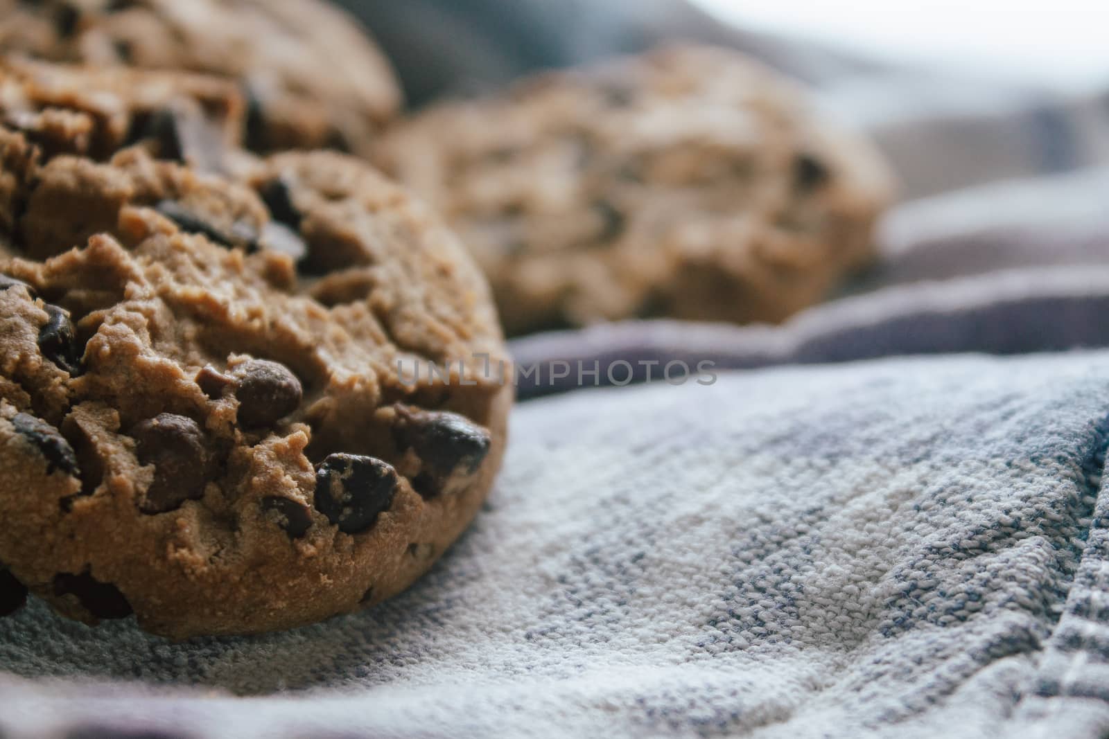American chocolate cookies on blue cloth prepared for breakfast in the morning sunlight.Ideal for a tasty breakfast
