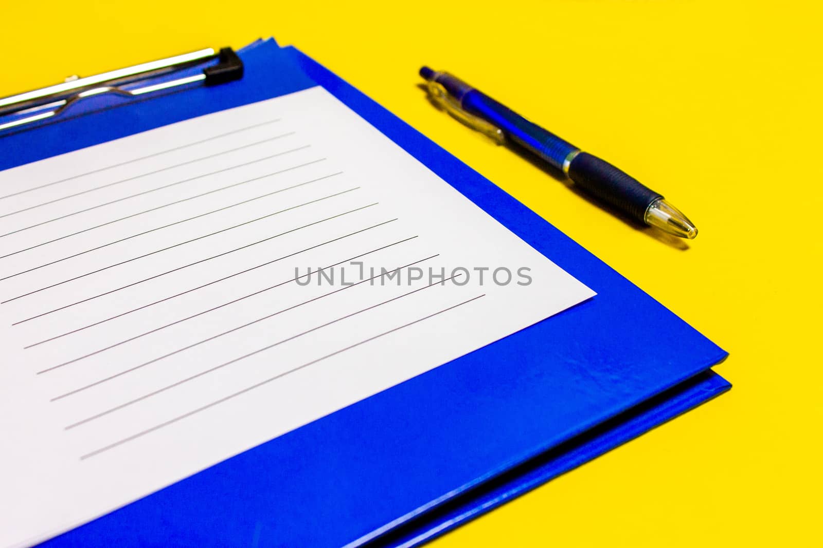 Blue corporate notes folder with blue pen isolated on white background. With sheets of writing paper.