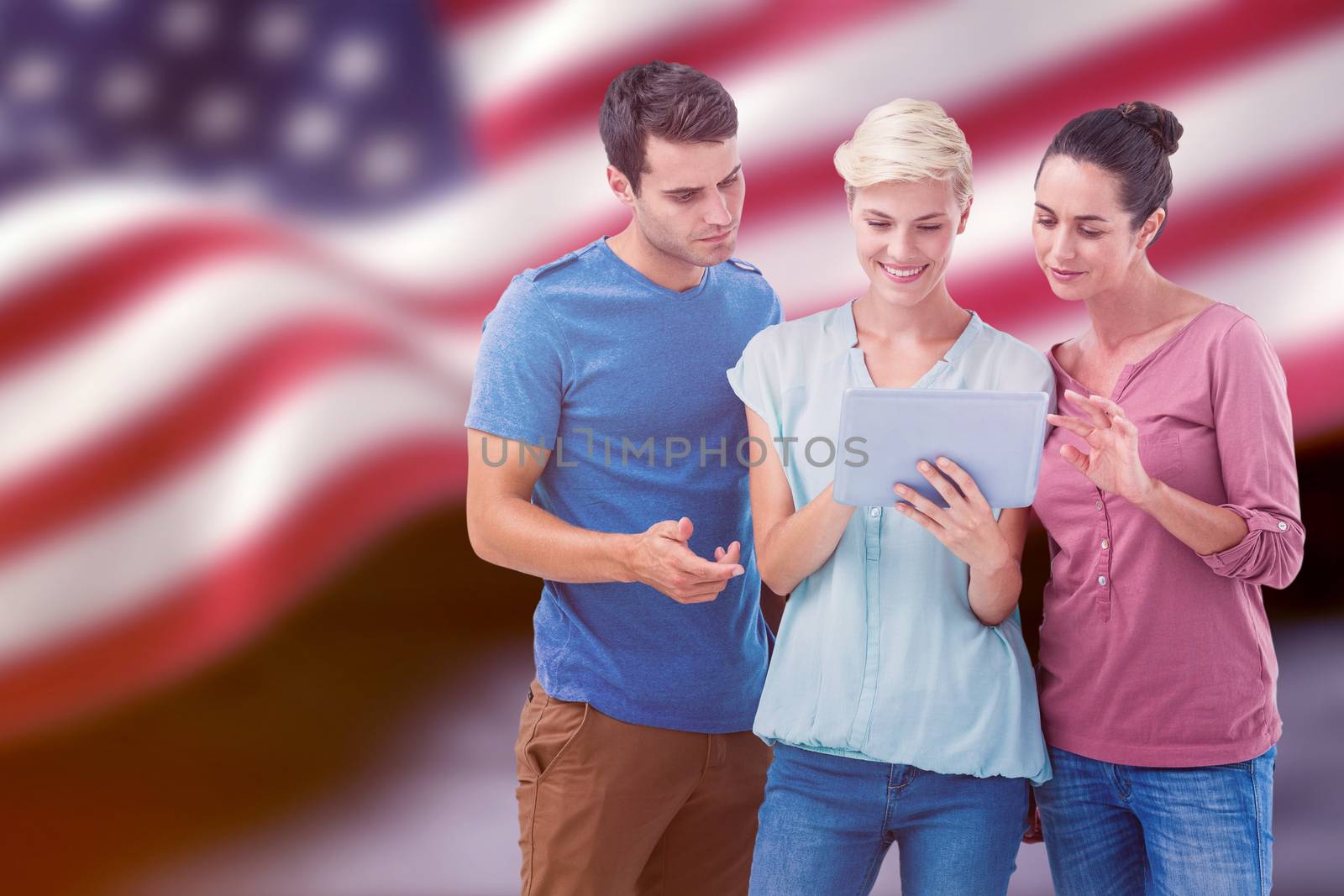 Group portrait of happy colleagues using tablet against composite image of digitally generated united states national flag