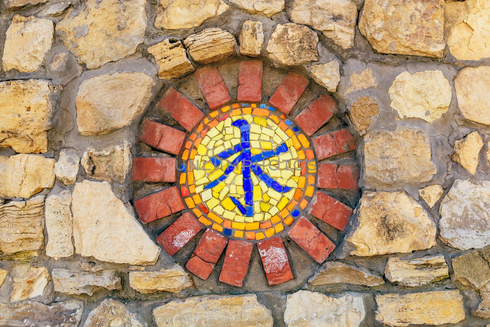 Circular mosaic religious symbol of confucianism on stone wall.