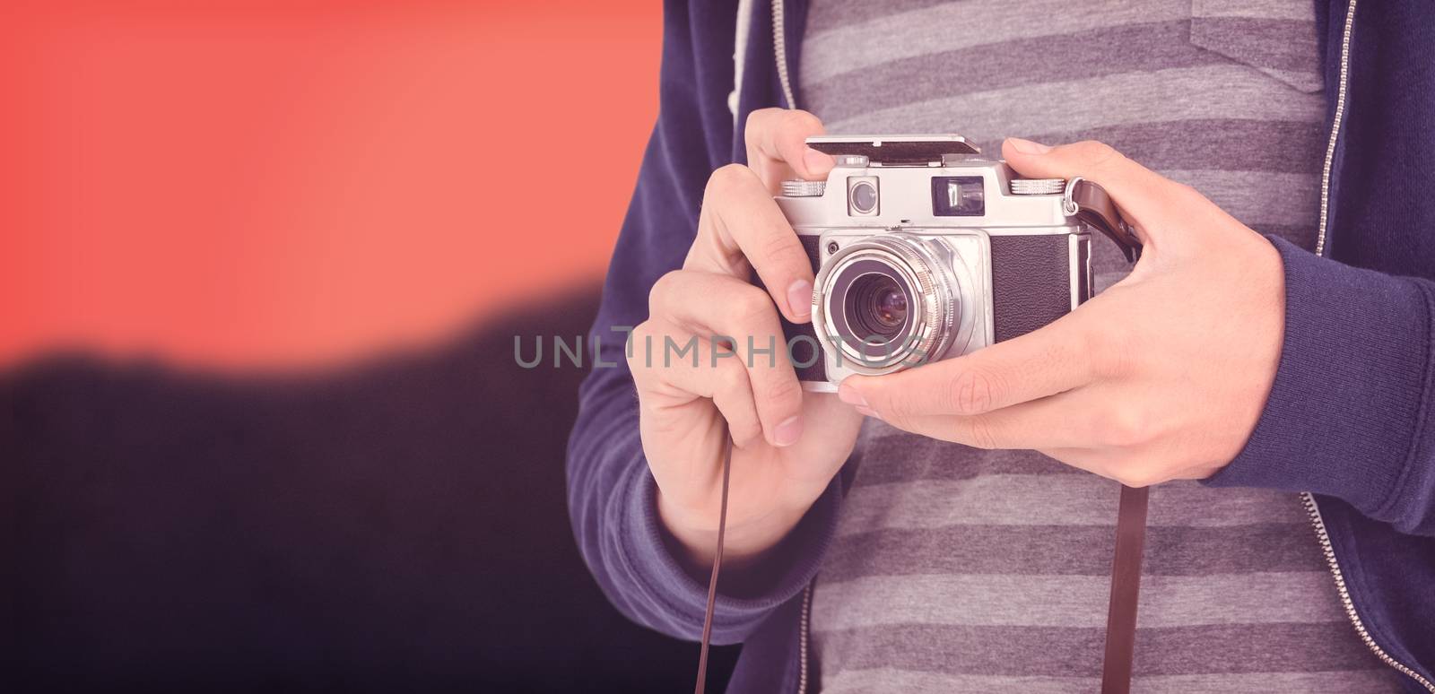 Mid section of man with camera against blurred mountains