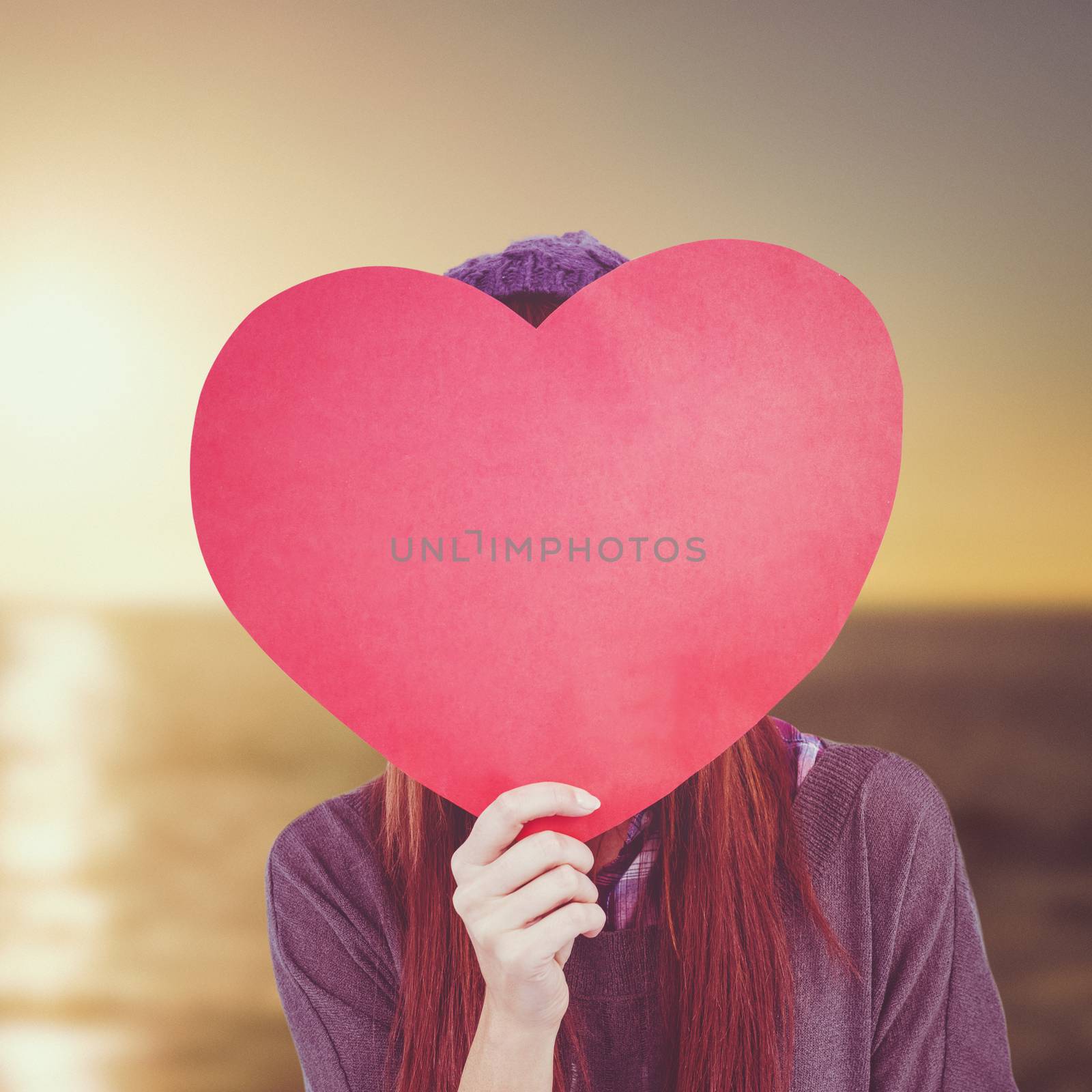 Hipster woman behind a red heart against sunset of a beautiful day