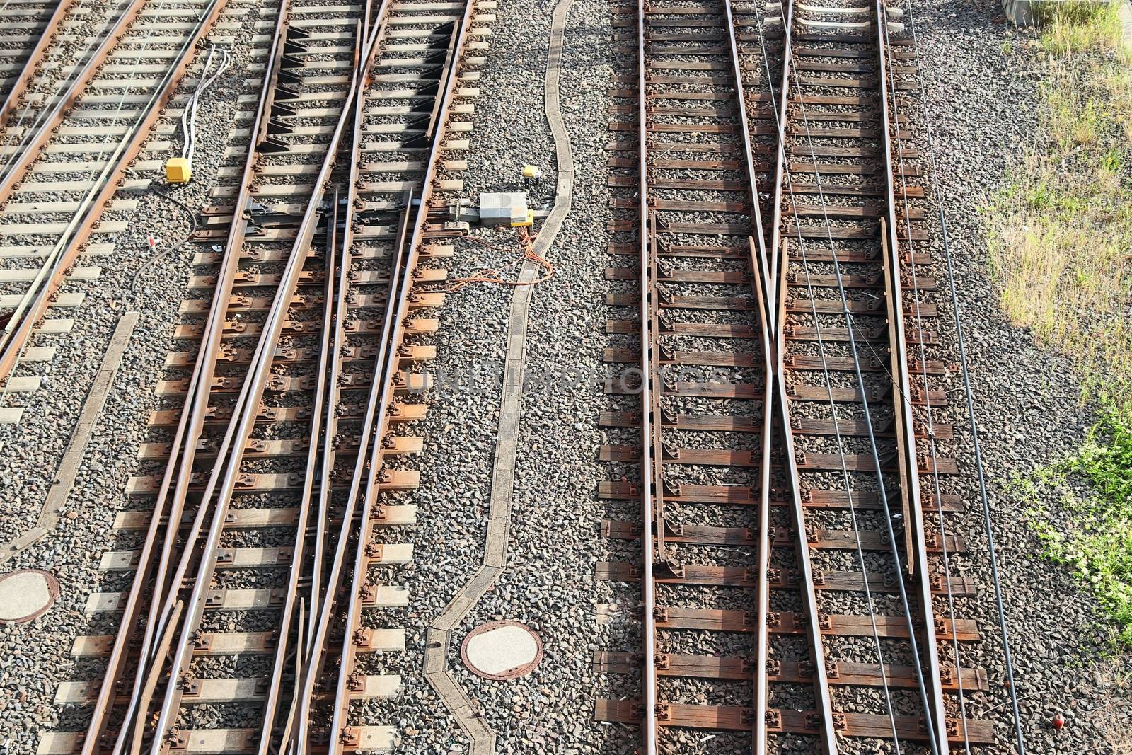 Multiple railroad tracks with junctions at a railway station in a perspective view