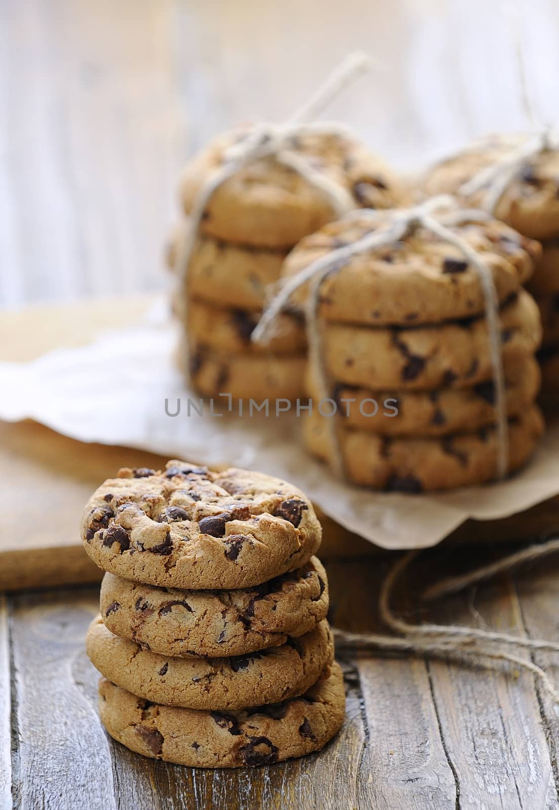 Close-up of several piles of chocolate cookies on wooden table.