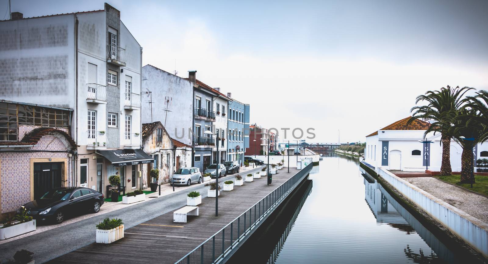 Aveiro, Portugal - May 7, 2018: view of the houses surrounding a canal with reflections in the historic city center on a spring day