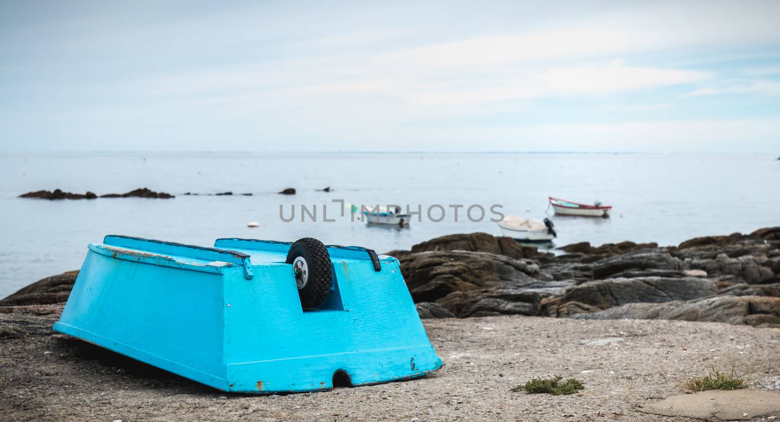 small blue boat at the edge of the Atlantic Ocean on the island of yeu, France