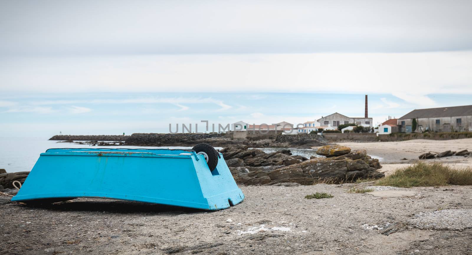 small blue boat at the edge of the Atlantic Ocean on the island of yeu, France