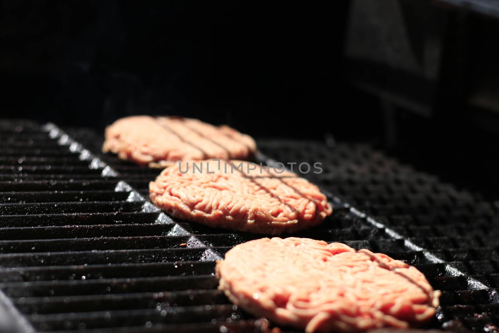 Raw burgers on bbq barbecue grill with fire. Food meat - raw burgers on bbq barbecue grill with fire. Shallow dof by mynewturtle1