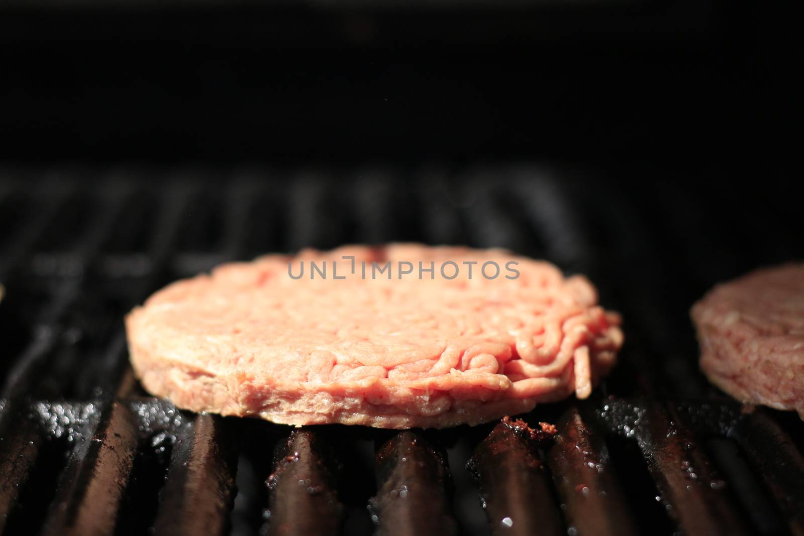 Raw burgers on bbq barbecue grill with fire. Food meat - raw burgers on bbq barbecue grill with fire. Shallow dof by mynewturtle1