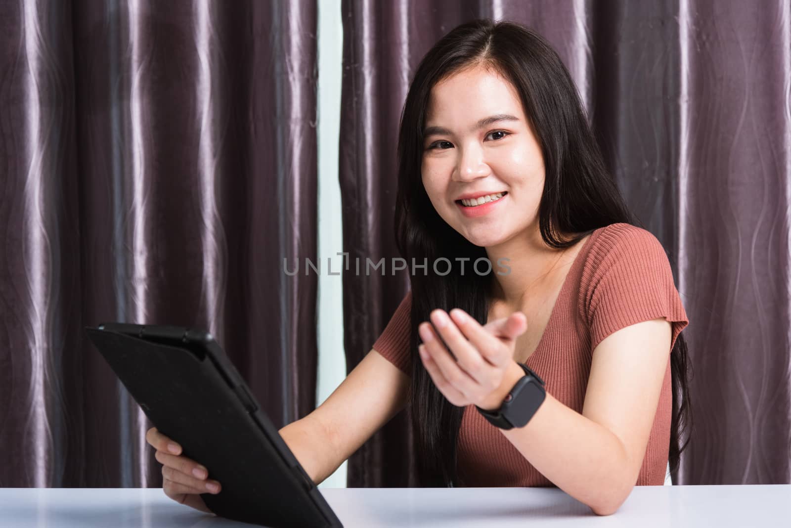 Work from home, Happy Asian business young beautiful woman sitting on desk workspace video call conferencing, write, check or read mail on digital tablet computer technology at home office