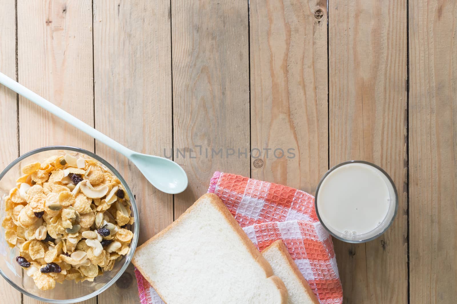 topview corn flakes,bread,milk on wooden table with copy space