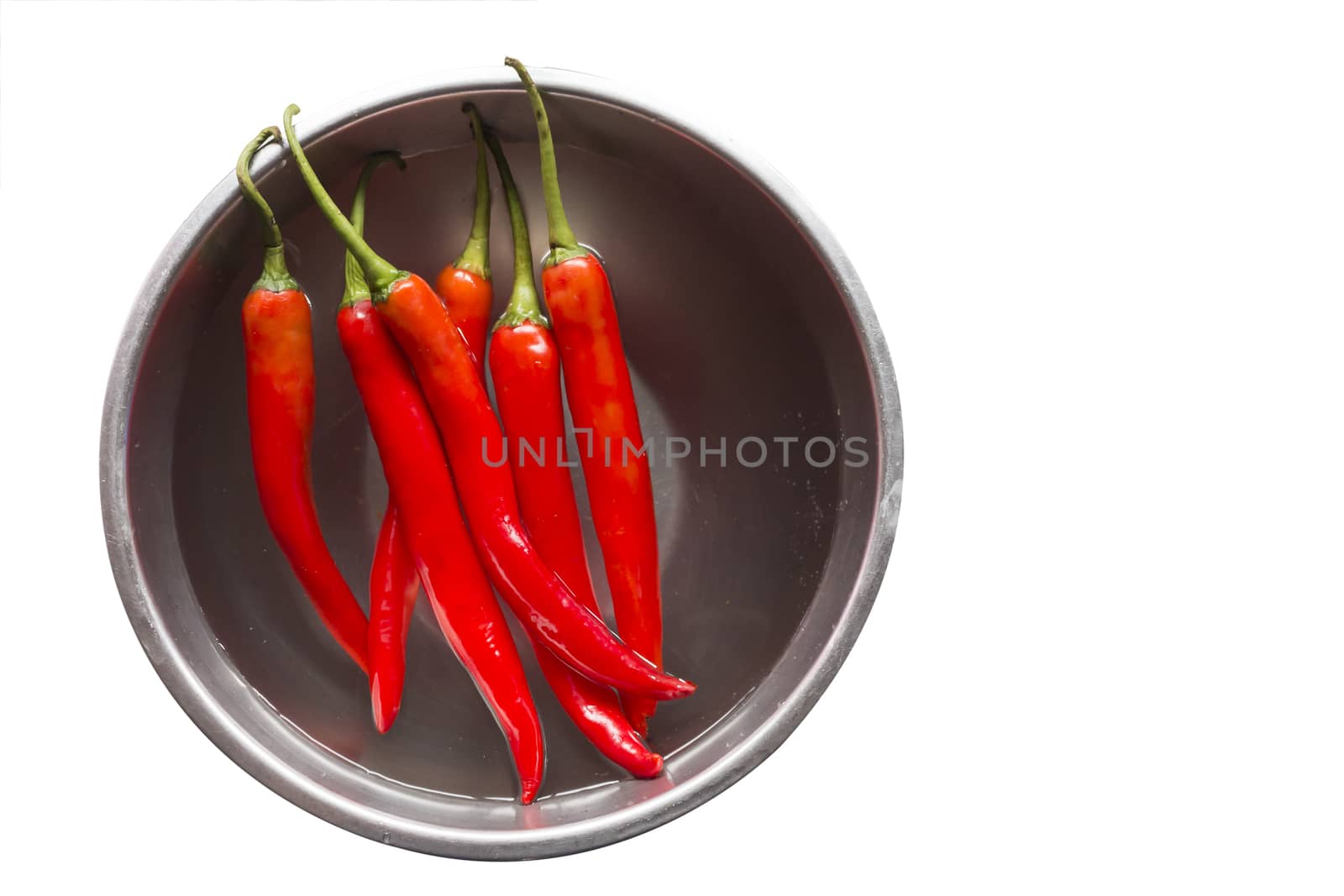 Fresh red chilli pepper in water on bowl of steel on white background,copy space