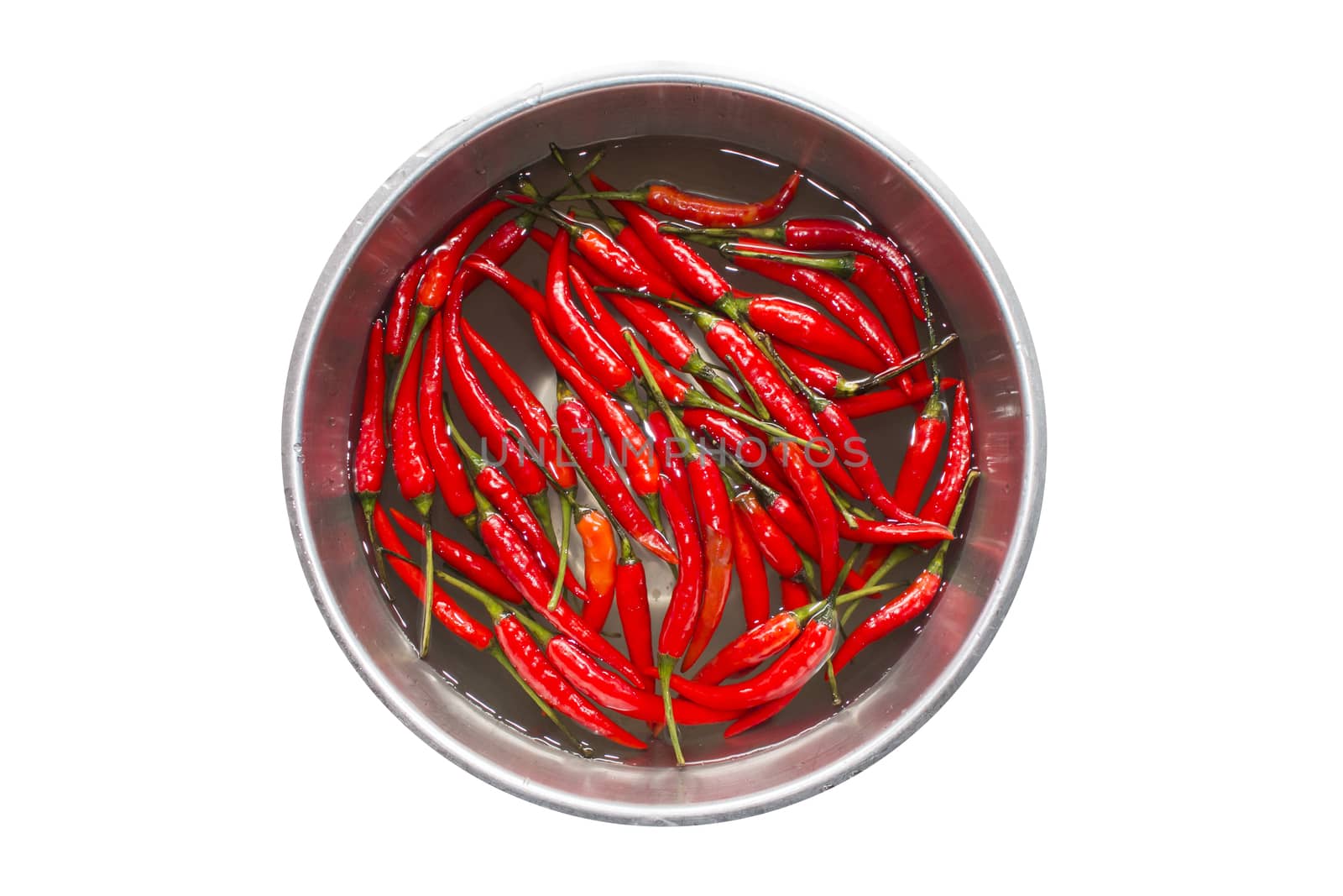 Top view of red chilli pepper in water on bowl of steel on white background