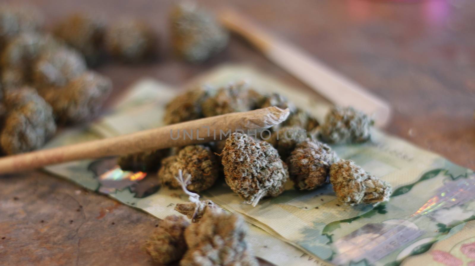Marijuana joint on top of buds of marijuana and Canadian twenty dollar bills by mynewturtle1
