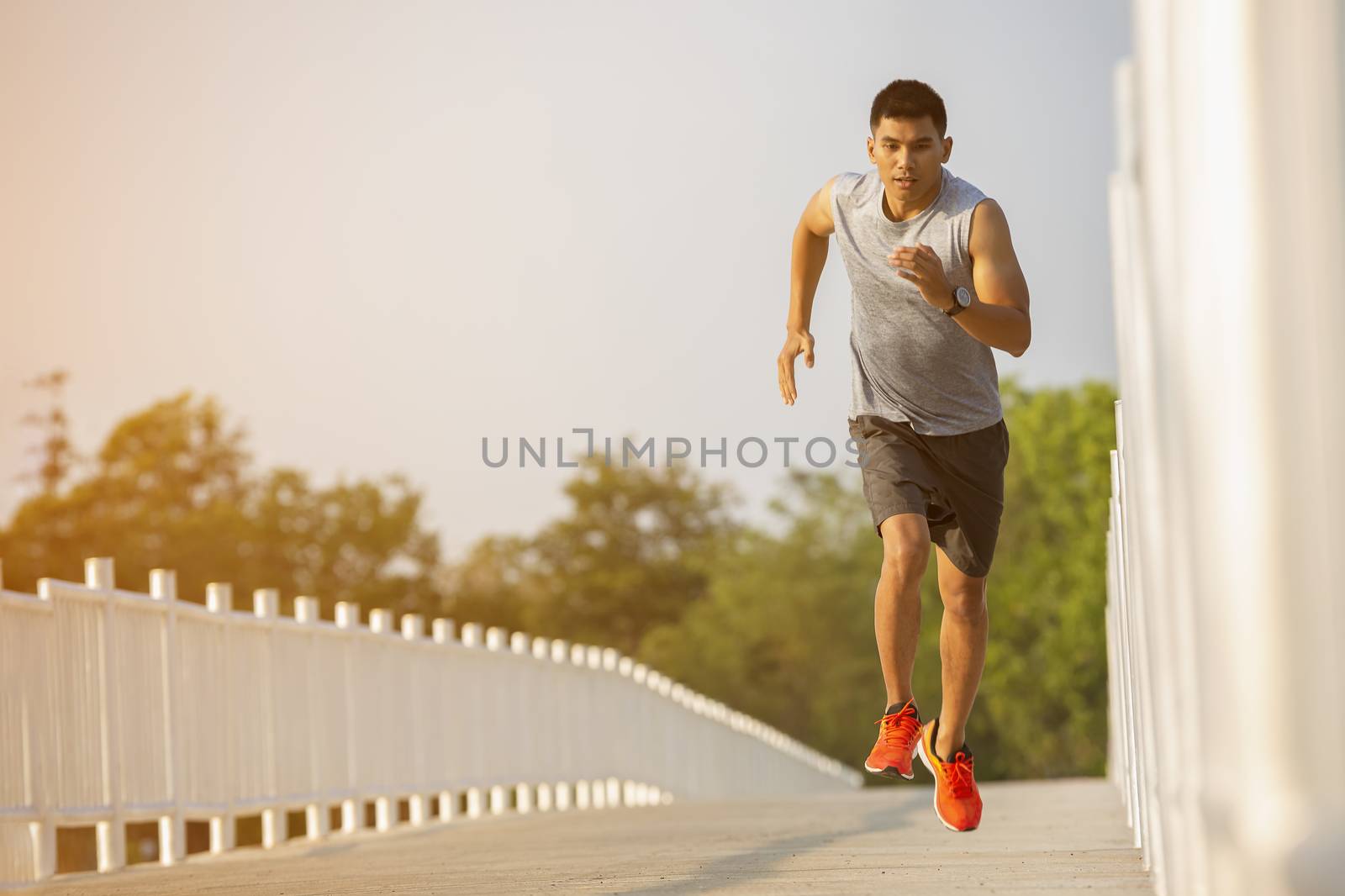 The silhouette of young men running and exercising at sunset with the sun in the background, colorful sunset sky