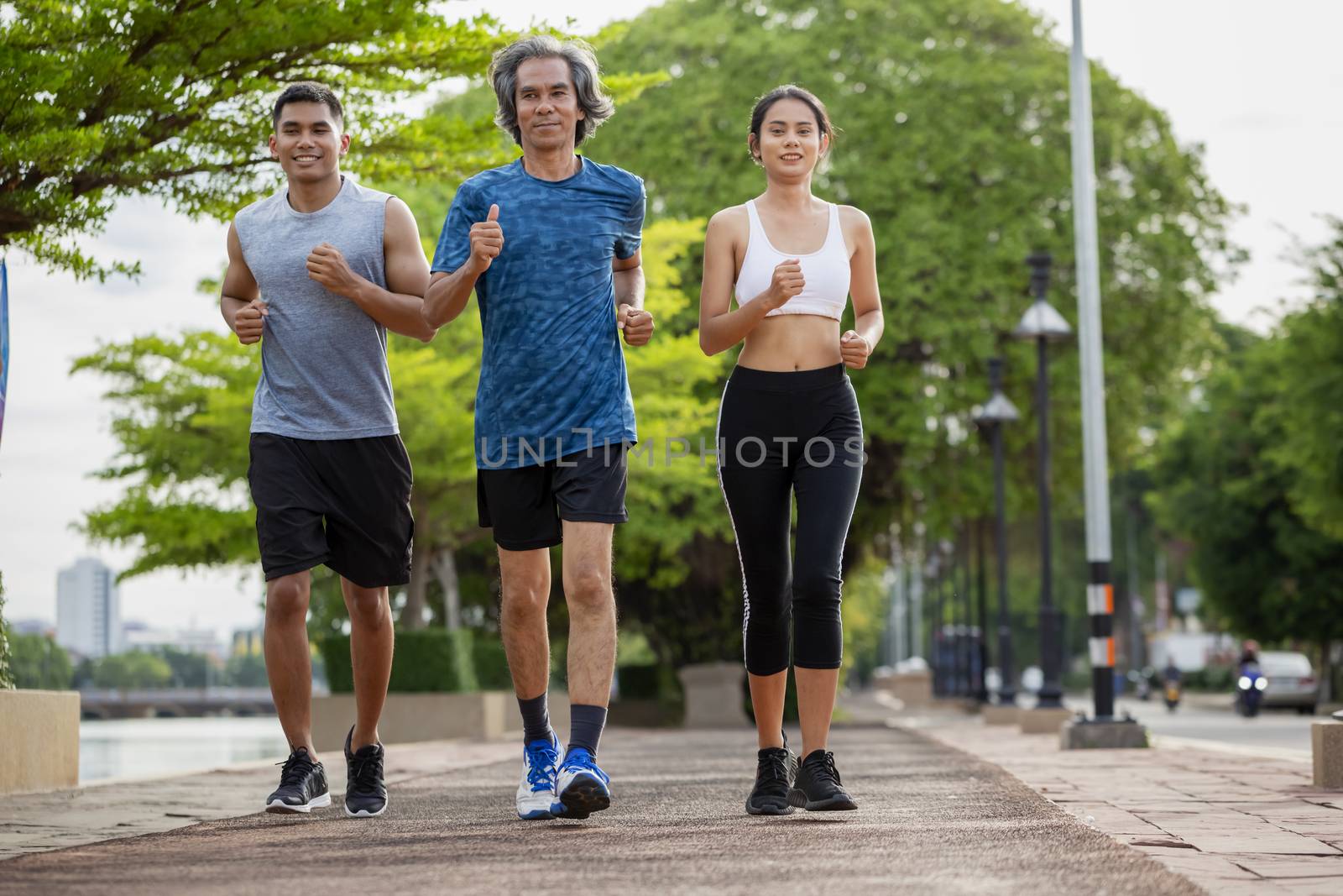 Family exercising and jogging together in the outdoor garden. Healthy family