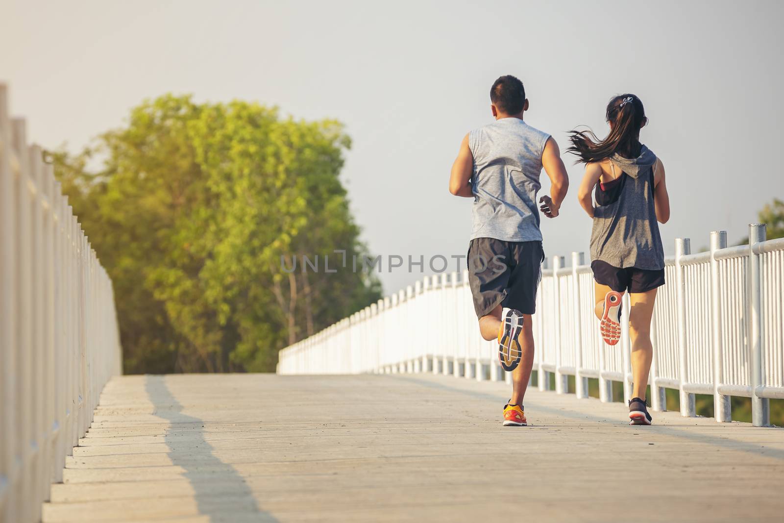 Silhouette of a couple running and exercising at sunset with the by numberone9018