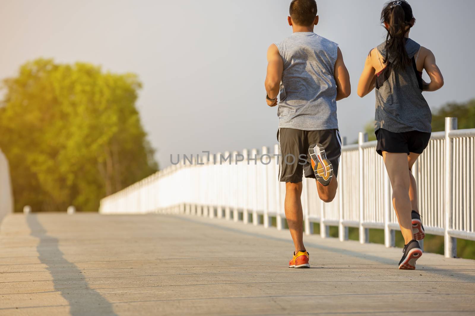 Silhouette of a couple running and exercising at sunset with the by numberone9018