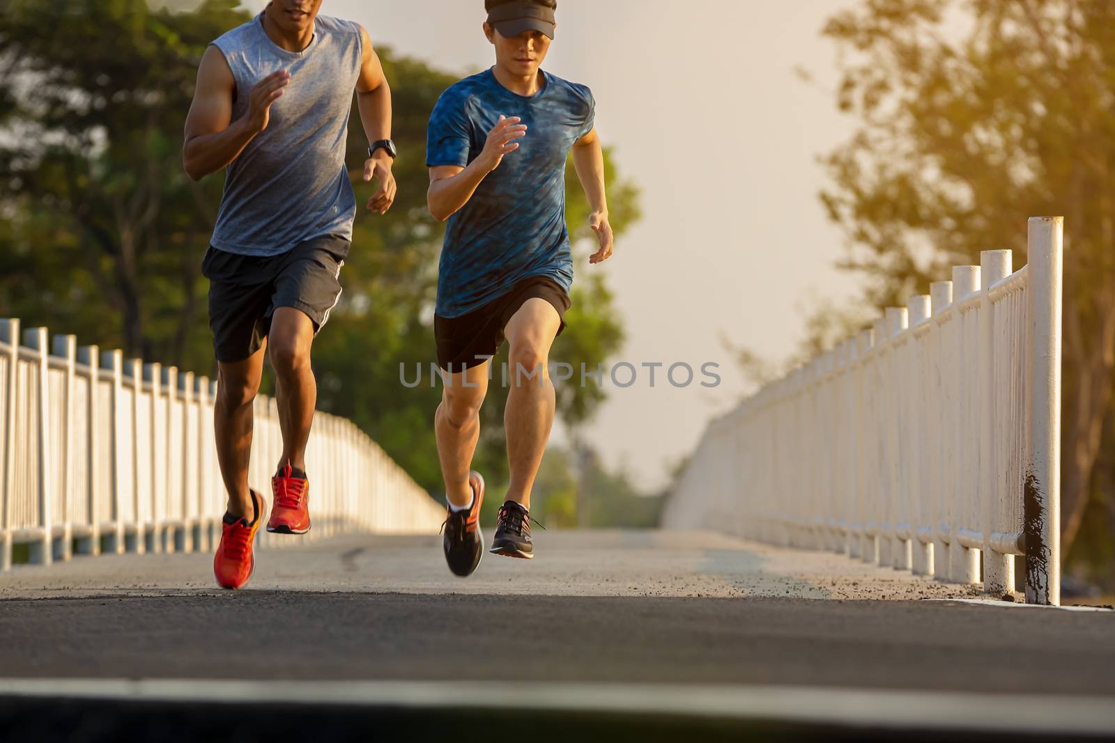 Silhouette of a couple running and exercising at sunset with the sun in the background, colorful sunset sky
