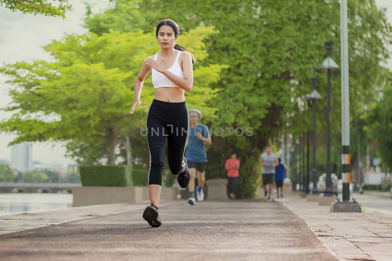 Portrait of beautiful woman running in the park in early morning. Healthy concept