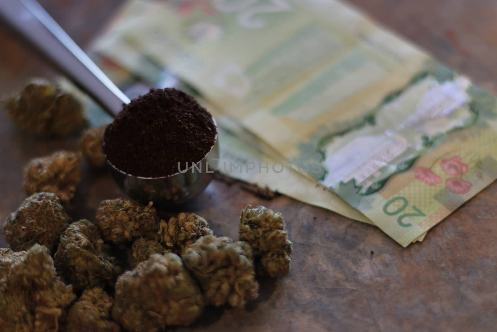 scoop of coffee next to weed or marijuana and twenty dollar bills.
