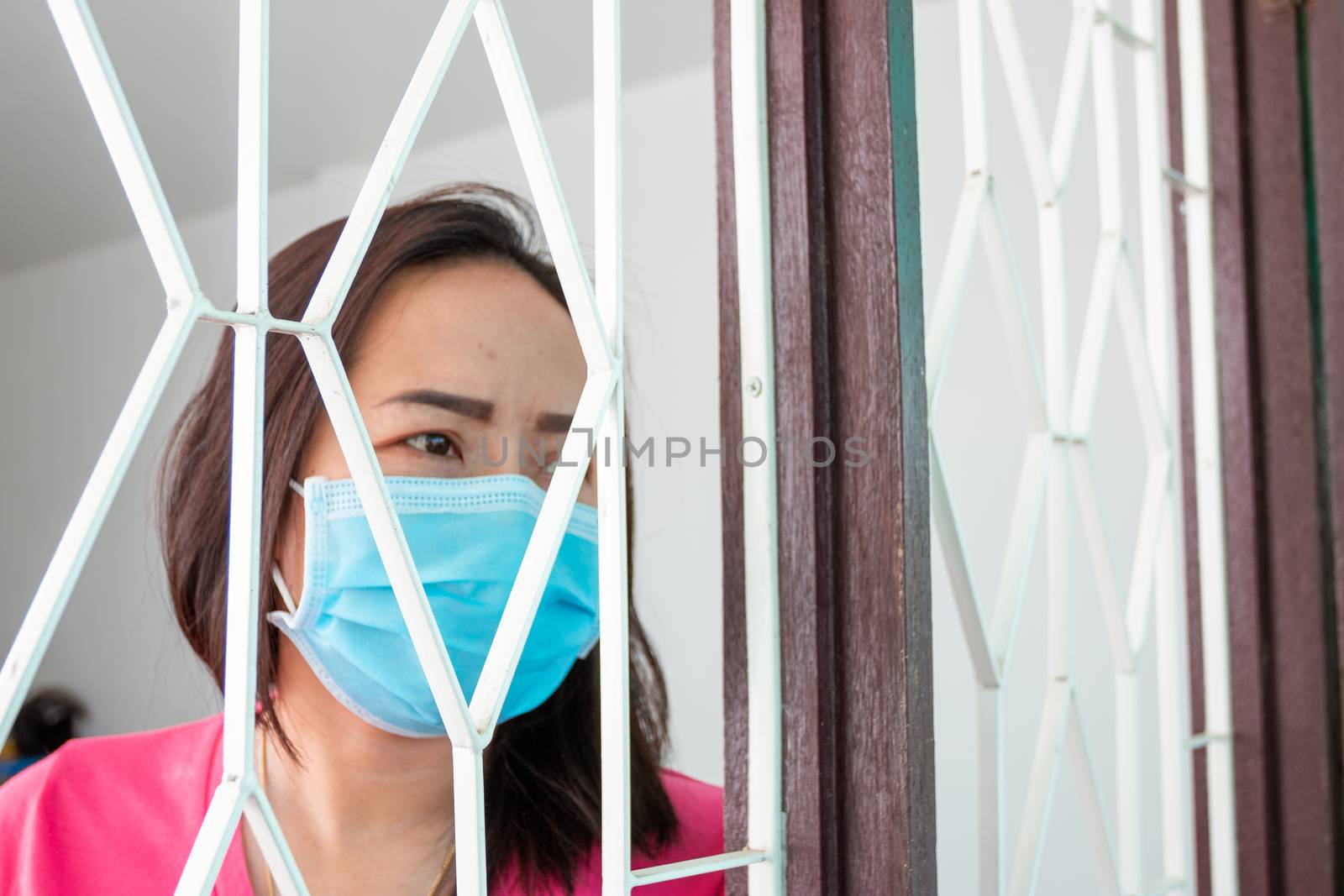 Corona virus (COVID-19), During detention at home Masked woman Feeling sad and lonely alone in the house Sometimes she uses her phone to make video calls to friends.